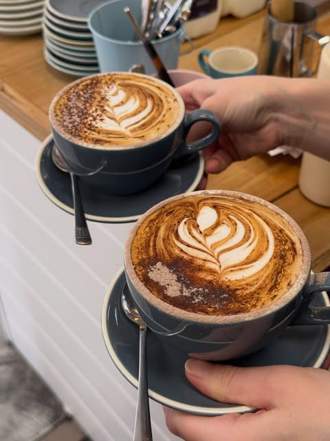 Two ceramic coffees with latte art at Milk Money Espresso