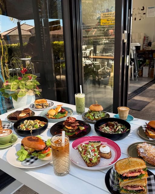 A table filled with burgers, toasties, breakfast plates and drinks at Milk Money Espresso